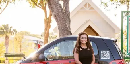 A woman in a black dress standing next to a red Smart car with 'Ladybug Mobile Notary Services' branding and a ladybug logo.