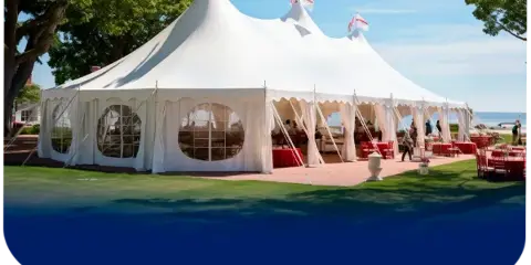 A large white event tent set up outdoors with tables and chairs for a wedding or special event.