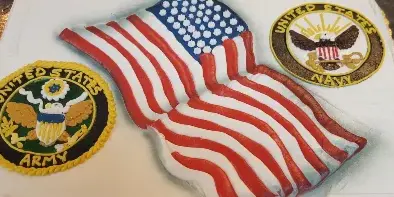 A white frosted cake decorated with a 3D American flag and military patches for the US Army and US Navy.