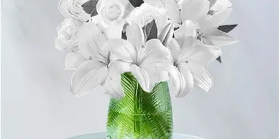White rose and lily bouquet in a green vase on a small table