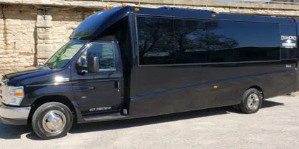 A black luxury shuttle bus parked outdoors.