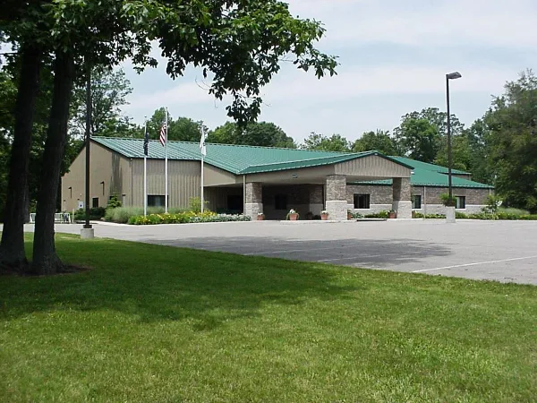 Exterior view of the Wells County 4-H Park Community Center building with a green roof and stone facade.