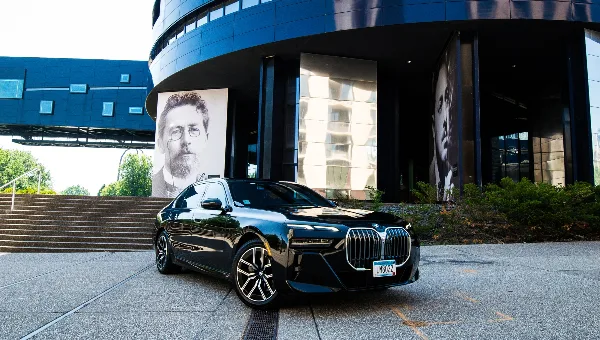Black luxury sedan parked in front of a modern building