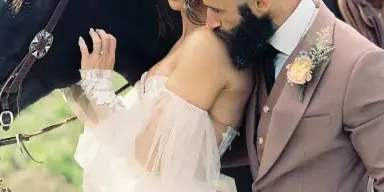 Wedding couple embracing outdoors next to a horse