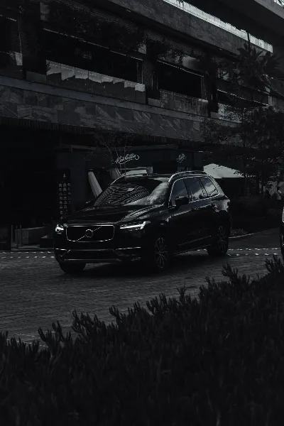 A black luxury SUV parked in front of a modern building.