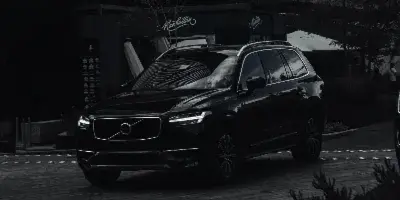 A black luxury SUV parked in front of a modern building.