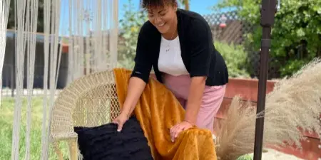 Shayna Holt arranging event decor on a wicker chair outdoors