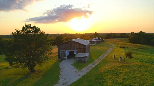 Aerial view of a wooden barn wedding venue on a farm at sunset