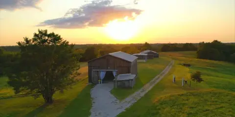 Aerial view of a wooden barn wedding venue on a farm at sunset