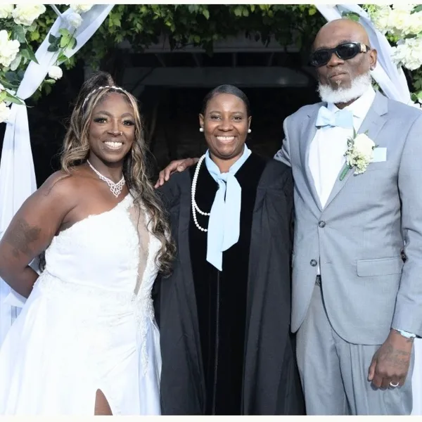 Dee taking a picture with the bride and groom at a wedding nyc