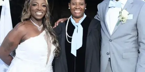 Dee taking a picture with the bride and groom at a wedding nyc
