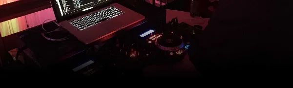 A professional DJ setup featuring a laptop and Pioneer DJ controller on a table.