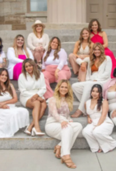 A group of women, presumably the bridal hair and makeup team, posing together on steps.