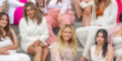 A group of women, presumably the bridal hair and makeup team, posing together on steps.