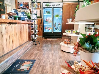 Interior view of a florist and gift shop with a floral display case and wooden counter.