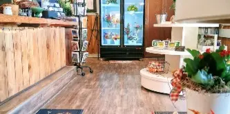 Interior view of a florist and gift shop with a floral display case and wooden counter.