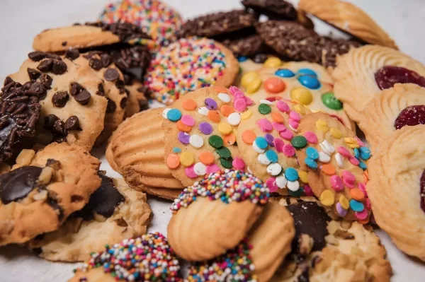 An assortment of freshly baked cookies including chocolate chip, sprinkle, and M&M varieties.
