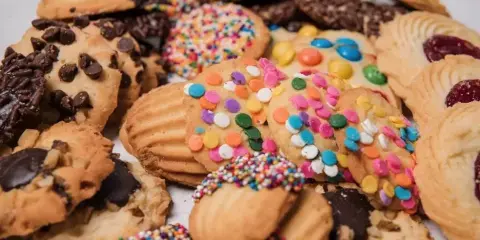 An assortment of freshly baked cookies including chocolate chip, sprinkle, and M&M varieties.