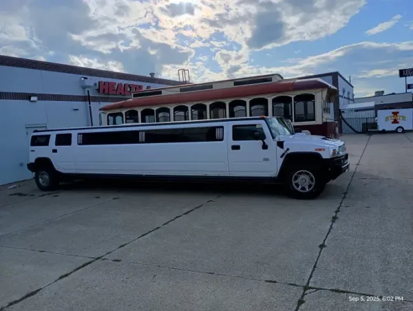 A white stretch Hummer limousine parked in a lot.