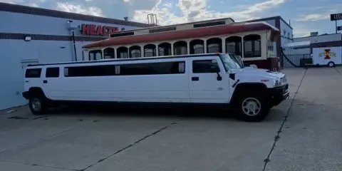 A white stretch Hummer limousine parked in a lot.