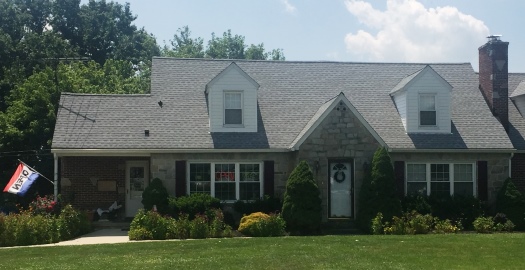Exterior view of a single-story brick and stone building with a gray shingled roof, serving as the Patti Parks Pizzazz Hair Salon.