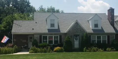 Exterior view of a single-story brick and stone building with a gray shingled roof, serving as the Patti Parks Pizzazz Hair Salon.