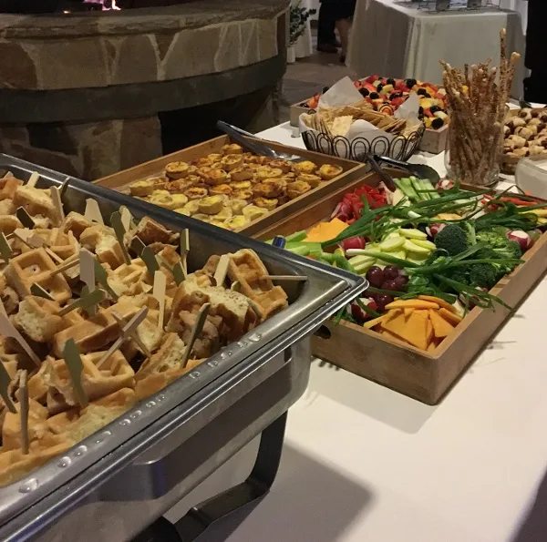Wedding appetizer buffet with savory bites, fruit, and vegetables