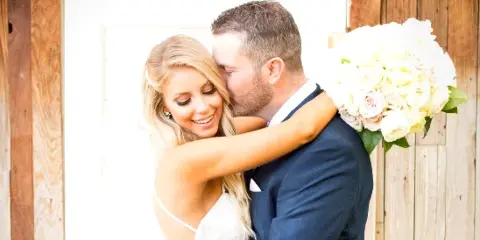 A bride and groom embracing in a wedding photograph.
