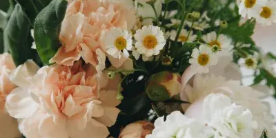 Close-up of a floral arrangement with peach peonies and white daisies