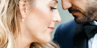 A close-up profile portrait of a bride and groom touching foreheads.