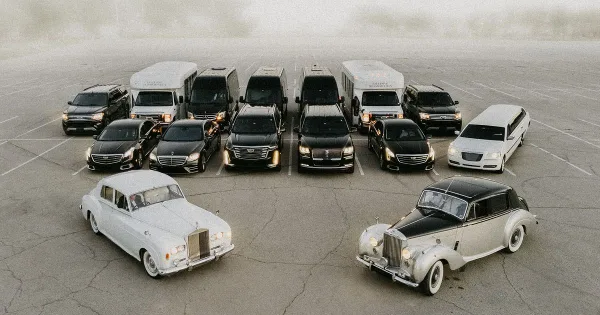 Aerial view of a luxury limousine fleet including vintage Rolls-Royce and Bentley cars, modern sedans, and SUVs parked in a lot.
