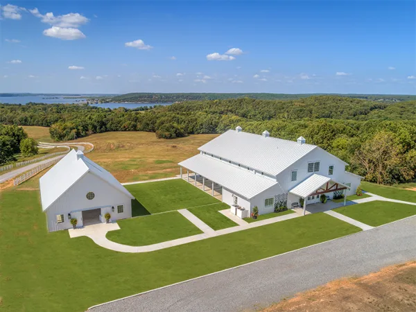 Aerial view of the Lakeview Hills wedding venue featuring white event buildings, manicured lawns, and a view of Lake Hudson.