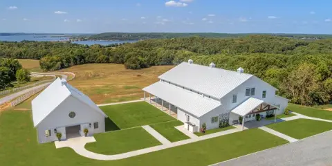 Aerial view of the Lakeview Hills wedding venue featuring white event buildings, manicured lawns, and a view of Lake Hudson.
