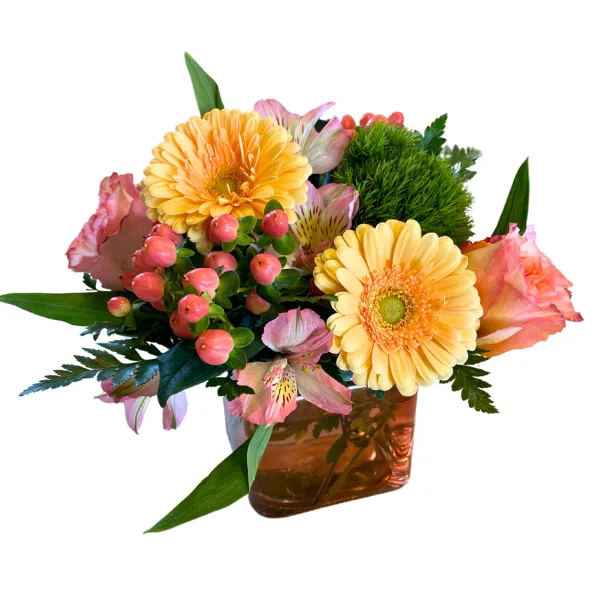 A floral arrangement featuring yellow gerbera daisies, pink alstroemeria, and pink berries in an amber glass vase.