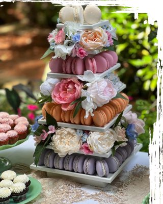 A multi-tiered wedding dessert tower decorated with macarons and fresh flowers.