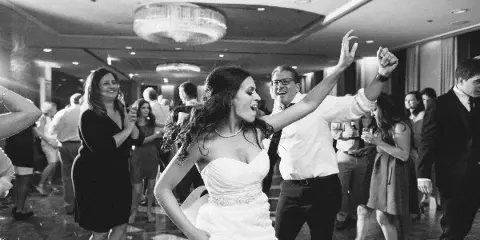 A bride dancing on a dance floor at a wedding reception.
