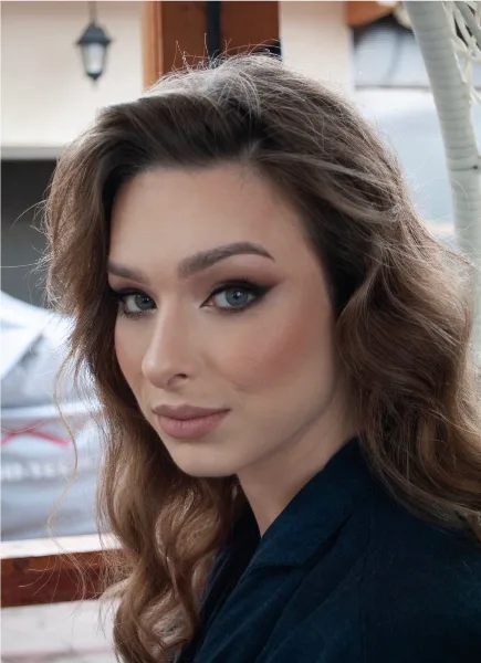 Close-up portrait of a bride with styled wavy hair and full bridal makeup.