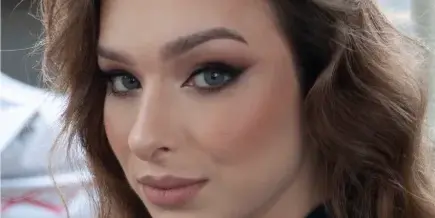 Close-up portrait of a bride with styled wavy hair and full bridal makeup.