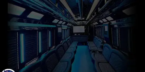 Interior view of a party bus featuring blue leather seating, ambient lighting, and a central aisle.