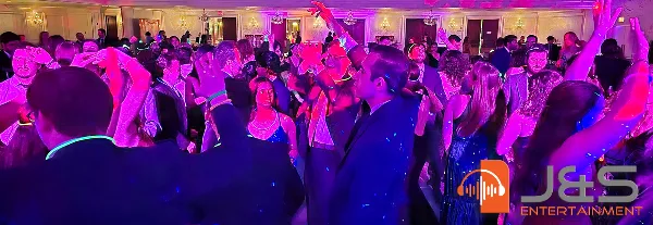 Guests dancing at a wedding reception under purple and blue lighting