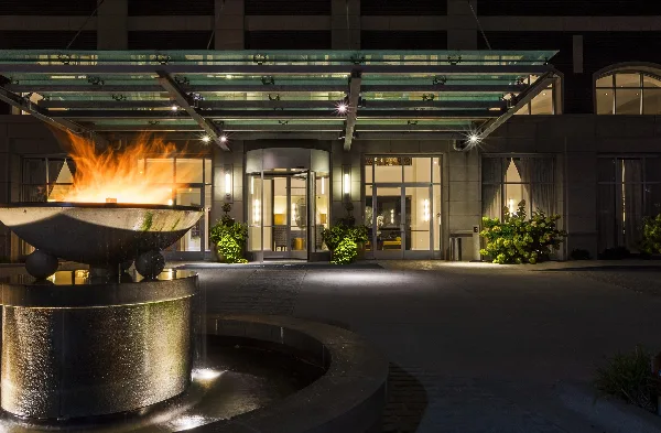 Nighttime exterior view of the Hotel Blackhawk entrance with a fire bowl and glass canopy.