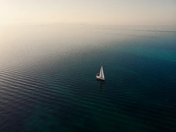 Aerial view of a sailboat on calm, turquoise water in the Florida Keys.