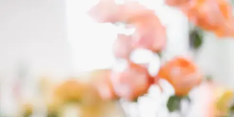 A close-up photograph of a bouquet of peach and orange roses with green stems.