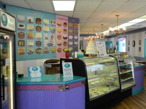 Interior of Sweet Stuff Bakery showing display cases of baked goods and a wedding cake.