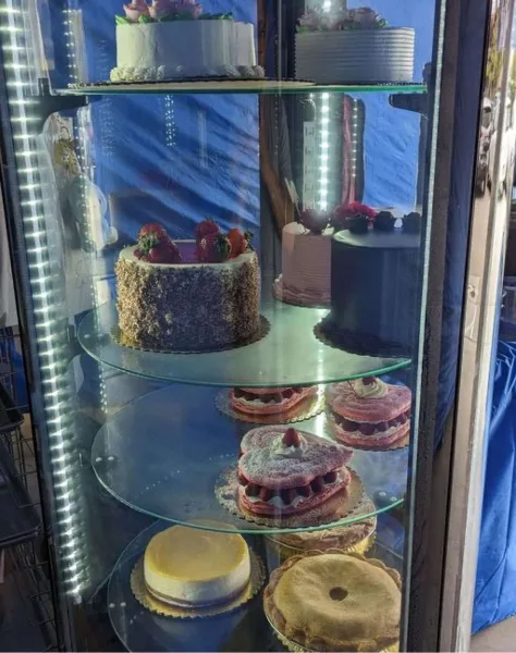 A glass display case filled with various French pastries, cakes, and tarts.