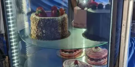 A glass display case filled with various French pastries, cakes, and tarts.