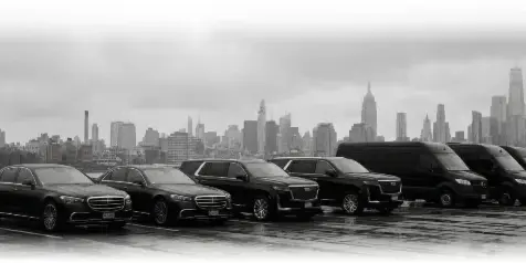 A lineup of luxury black sedans, SUVs, and vans parked in front of the New York City skyline.