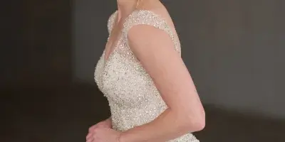 Bride in a beaded wedding gown with styled hair and makeup