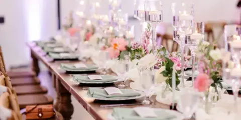 A long reception table styled with pink florals and elegant place settings at Hyla Brook Estate.