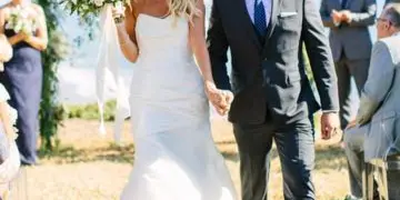 A bride and groom walking down the aisle at an outdoor wedding ceremony.